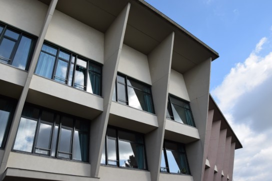 Foto van gebouw woonzorgcentrum De Ceder in Beersel Gebouw met grote ramen en verticale betonnen gevels tegen een blauwe lucht. (vergroot foto)