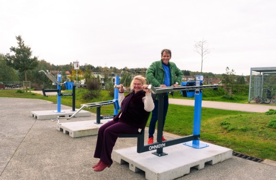Twee mensen gebruiken fitnessapparaten in een openbaar park. (vergroot foto)